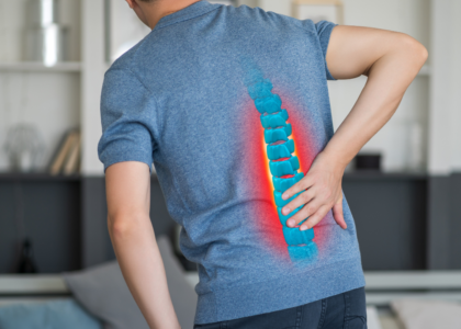 A person sitting on bed with lower back pain